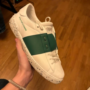 VALENTINO OPEN FOR A CHANGE - TVÄR FETA SPRILLANS nya valentino open sneakers i open for a change modell med ett mörktgrönt streck. vilken kommer bli uppcoming. Dustbag medföljer ej byten! SJÄLVJÄVLA KLART ÄKTA VARA, TA KONTAKT INNAN KÖP