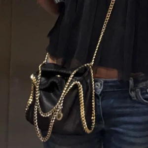 Stella McCartney väska - Stella McCartney Tiny, svart med guldkedjor. En lång axel kedja och en kort.  Defekter som att kedjorna har tappat lite färg och en liten skråma på lädret, där av priset. Kvitto och dustbag tillkommer, skriv för fler bilder och frågor.🥰❤️(skriv gärna innan ni köper💖)