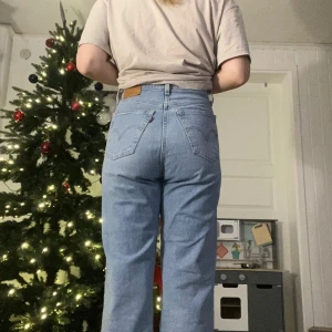 Blå Levi’s  jeans med hög midja - Snygga blå jeans med hög midja och klassisk femficksdesign. De har en rak passform och är perfekta för en avslappnad stil. Passar bra till både t-shirt och tröja. W28 jag är 171 lång 