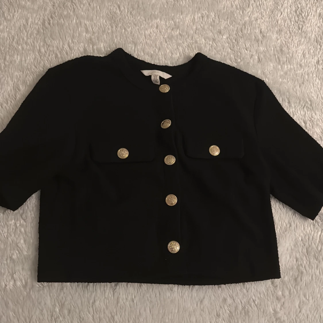 Svart kavaj med guldknappar