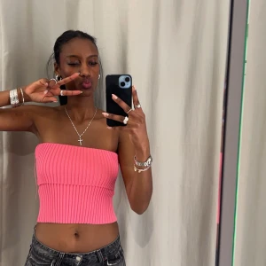 Zara Rosa ribbad tubtopp - Snygg rosa ribbad tubtopp som är perfekt för sommaren. Den är ärmlös och har en tight passform som framhäver figuren. Perfekt att matcha med jeans eller kjol för en trendig look. Använts enstaka gånger.