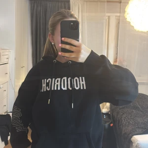 Svart hoodie från Hoodrich - Säljer en svart hoodie från Hoodrich med tryck både fram och bak. Den har en justerbar dragsko i huvan och en stor ficka framtill. Har inte använt mycket alls och har inte heller användning för den. 