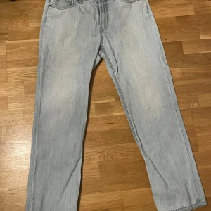 Ljusblå jeansbyxor - Säljer ett par ljusblå jeansbyxor med en klassisk femficksdesign. Byxorna har en rak passform och är perfekta för en avslappnad stil. De är tillverkade i ett bekvämt denimtyg.