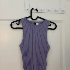 Lila ribbad linnetopp från H&M Divided - Säljer en snygg lila ribbad linnetopp från H&M Divided. Toppen är ärmlös och har en tight passform, perfekt för sommardagar. Den är tillverkad i ett mjukt och stretchigt material.