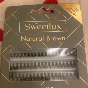 Sweetlux Natural Brown Cluster Lashes - Sweetlux Cluster Lashes i färgen Natural Brown. Perfekta för att skapa en naturlig look med fylligare fransar. Innehåller flera rader av klusterfransar som enkelt kan appliceras för att ge volym och längd.