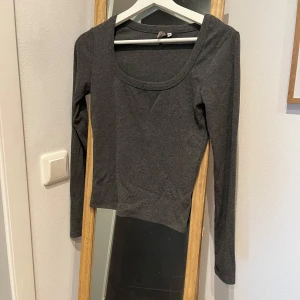 Grå ribbad långärmad topp - Säljer en stilren grå ribbad topp med långa ärmar. Toppen har en rund halsringning och är gjord i ett mjukt material. Den är från Nelly och i strl S. Använd men i väldigt fint skick✨