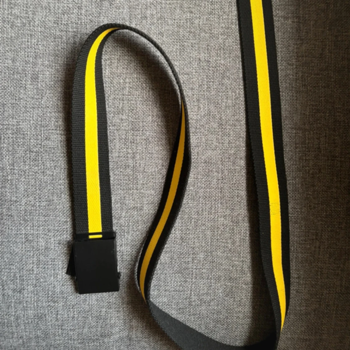 Svart och gult bälte med spänne