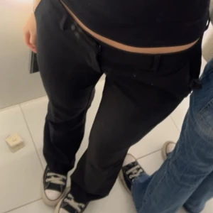 Svarta kostymbyxor - Snygga svarta kostymbyxor med en klassisk design. De har en rak passform och är perfekta för en stilren look. Byxorna är lågmidjade och tillverkade i ett bekvämt material som ger en elegant siluett. Från bikbok i storlek 38, HELT NYA! 