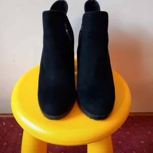 Svarta bershka boots med dragkedja - Snygga svarta boots från Bershka med dragkedja på sidan. De har en klack som ger extra höjd och stil. Perfekta för att komplettera din outfit med en elegant touch.