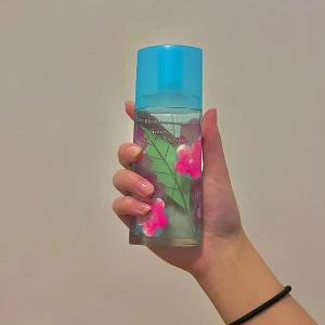 Elizabeth Arden Green Tea Sakura Blossom - Fräsch parfym från Elizabeth Arden med doft av grönt te och sakura-blommor. Flaskan är dekorerad med rosa blommor och har ett blått lock. Perfekt för en uppfriskande känsla.