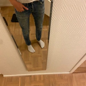 Blå jeans från Dondup - Snygga blå jeans från Dondup med en klassisk design. De har en lätt tvättad look och är perfekta för en avslappnad stil. Jeansen har en knappgylf och är tillverkade i ett slitstarkt denimtyg. Storleken är 33. Modell: George. 