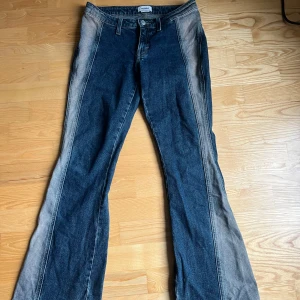 Blå jeansbyxor från Weekday - Snygga blå jeansbyxor från Weekday med en unik tvättad look. Byxorna har en klassisk femficksdesign och knäppning med dragkedja. Perfekta för en avslappnad stil.