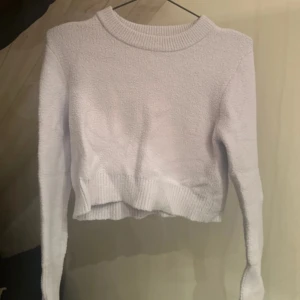 Ljuslila stickad tröja - Säljer en mysig stickad tröja med långa ärmar och ribbad kant vid halsen. Tröjan är croppad och perfekt för kyligare dagar. Passar bra till både jeans och kjol. Perfekt för dig som älskar en stilren look!