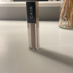 Concealer från CAIA - Snygg concealer från CAIA i en stilren, transparent förpackning med silverlock. Perfekt för att täcka ojämnheter och ge en jämn hudton.