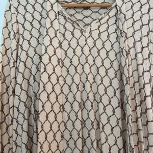 Mönstrad blus från Stockh LM - Snygg blus från Stockh LM med ett unikt mönster i beige och brunt.