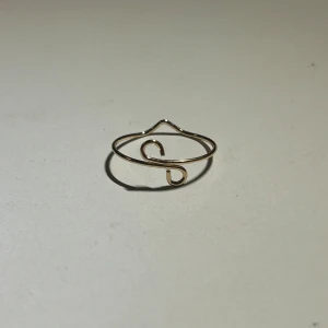 Guldfärgad ring - Passar bra på alla fingrar och är lätt att matcha med andra smycken. Går att justera storleken