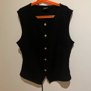 Svart topp  - Svart topp från Gina med guldknappar 