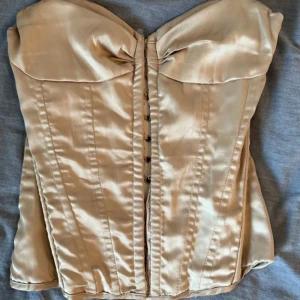 Guldig vintage korsett🩰 - Säljer denna otroligt fina guldiga vintage korsett. Går att spänna åt där bak och är i nyckick trots att denr gammal🫶🏽