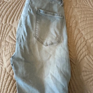 Ljusblå jeans med fransar - Snygga ljusblå jeans med fransar vid bensluten. De har en klassisk femficksdesign och en avslappnad passform. Perfekta för en casual look.