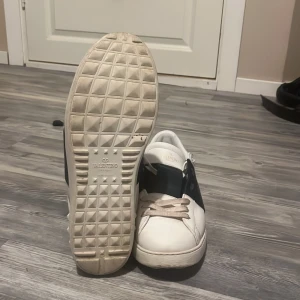 Valentino sneakers i vitt och svart - Snygga Valentino sneakers i vitt med svarta detaljer. Skorna har en klassisk design. Perfekta för en stilren look. Vill också byta eftersom mina var för små och skulle vilja byta mot ett par som är 44
