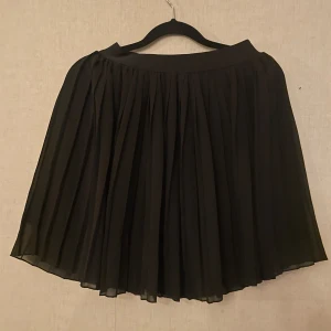 Svart kjol från NA-KD - Snygg svart plisserad kjol från NA-KD.  Använd 1 gång 