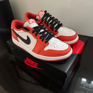 Nike Air Jordan 1 Low OG Starfish -  Nike Air Jordan 1 Low OG Starfish sneakers. Originalbox, svarta och oranga snören ingår. Skorna är i bra skick, använd 1-2 gånger. 