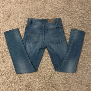 Ljusblå nudie jeans - Säljer ett par ljusblå nudie jeans i storlek W25 L30 i modellen high Kai. Nypris runt 1600.De har inga defekter. Skriv till mig om ni har en fråga