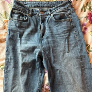 Blå jeans från Djerf Avenue - Snygga blå jeans från Djerf Avenue i strl 27. De har en broderad detalj med ett hjärta på bakfickan. Använda 1 gång, nypris 1500kr