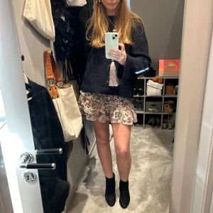 Blommig kortkjol med volang - Säljer en söt ZARA kortkjol med blommigt mönster i beige, rosa och svart. Kjolen har volangdetaljer som ger en lekfull känsla. Perfekt för varmare dagar! Har ett litet hål men syns ej!