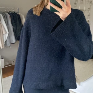 Mörkblå stickad tröja - Säljer en mysig mörkblå stickad tröja med långa ärmar. Perfekt för kyliga dagar och har en enkel, stilren design. Passar bra till både jeans och kjol. Den är i storlek s men passar M , köpt för 500. Den är lite nopprig men inget man tänker på. 
