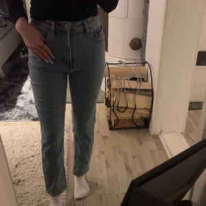 Blå slim mom jeans  - Säljer ett par snygga blå mom jeans från Stradivarius. De har en hög midja storlek 36. 