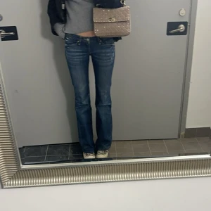 Blå bootcut jeans  - Super coola och snygga blå vintage bootcut jeans från MY BOYFRIENDS JEANS med låg midja och coolt randigt tyg som syns vid framfickorna. Perfekta för en avslappnad stil. De har en lätt tvättad look och stängs med dragkedja och knapp. Innerbenslängd 81 cm, midjemått 76