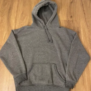 Grå hoodie från Bik Bok - Säljer en grå hoodie från Bik Bok i storlek S. Den har en klassisk design med en stor ficka framtill och justerbar luva, hör av er vid funderingar annars ge prisförslag🤗