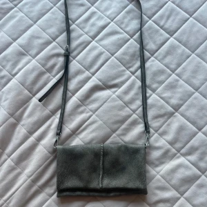 Grå axelväska från S.Oliver - Snygg grå axelväska från S.Oliver. Väskan har en justerbar axelrem. 