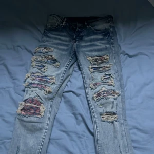 Slim fit jeans - Coola blå jeans med slitningar och hål på framsidan. De har en klassisk femficksdesign och en ljus tvätt som ger en avslappnad look. Perfekta för en trendig stil. Dom har inget märke men köpte för 1k och har använt dom 1 gång