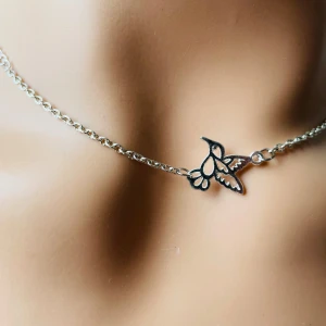 By prisförslag- Silverhalsband med fågel hänge  - Elegant silverhalsband med ett delikat fjärilshänge. Perfekt för att lägga till en subtil touch av naturinspirerad skönhet till din look. Kedjan är tunn och smidig, vilket gör den bekväm att bära hela dagen.
