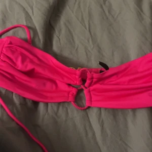 Rosa bikiniöverdel från Victoria's Secret - Snygg rosa bikiniöverdel från Victoria's Secret med gulddetaljer. Den har en knytning framtill och justerbara axelband för perfekt passform. Perfekt för en dag på stranden eller vid poolen. 💖