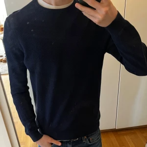 Blå tröja från Massimo Dutti - Säljer en stilren blå tröja från Massimo Dutti. Tröjan är tillverkad i en mjuk blandning av bomull och kashmir, vilket ger en lyxig känsla. Den har en rund hals och långa ärmar, perfekt för kyligare dagar. Passar både till vardags och mer uppklädda tillfällen. Skicket är mycket bra och inga defekter eller liknande förekommer. Hör gärna av vid frågor, funderingar eller prisförslag:)