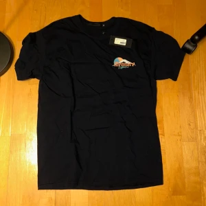 Svart t-shirt med draktryck från Menace -  Svart t-shirt från Menace med ett stort draktryck på baksidan och en mindre logga på framsidan. Det står Xs men den passar mig bra och jag har M, så den är stor i storlek