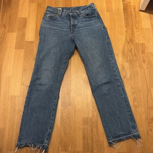Blå Levis 501 90s jeans - Jag säljer dessa blåa Levi’s jeansen. Dem är inte jätteanvända eftersom dem alltid har varit lite för små för mig. Dem är nästan som nya och har inga slitage förutom längst ner på byxorna där jag sprättat upp jeansen för att få lite extra längd men det går lätt att sy upp igen. Jeansen är storlek W26 och L30
