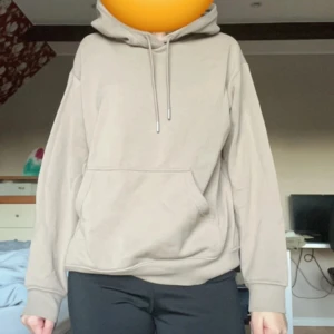 Beige hoodie - Säljer en stilren beige hoodie med känguruficka och justerbar huva. Perfekt för en avslappnad look. Passar bra till både jeans och träningsbyxor.
