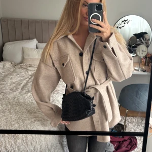 Beige kappa med bälte - Säljer en superfin beige kappa med bälte i midjan. Perfekt för höst och vinter!! Går att använda med och utan bälte. Väldigt fint skick då den knappt är använd ❣️köpt för 699kr