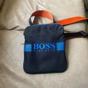 Hugo boss väska som inte säljs längre i helt ok skick enda defekten är den blå som har lossnat 