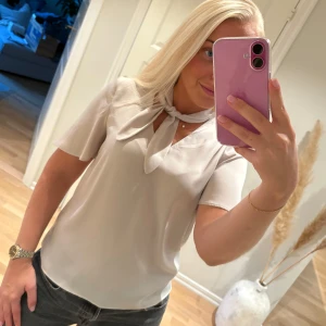 Blus i silkesmaterial - Blus i silkesliknande material. Nyskick. Storlek 34. Beige/champagnefärg.