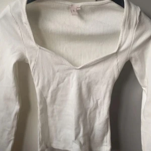 Nelly topp  - Långärmad uringad tröja från Nelly. Helt ny och prislappen sitter kvar. Storlek xxs men passar även xs och kanske s då den är stor vid axlarna