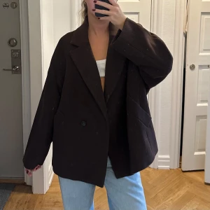 Brun Lindex kappa  - En oversized, kort & mysig höstkappa i ull. Perfekt med en tjocktröja under eller till boots. Använd endast ett fåtal gånger, som ny. 
