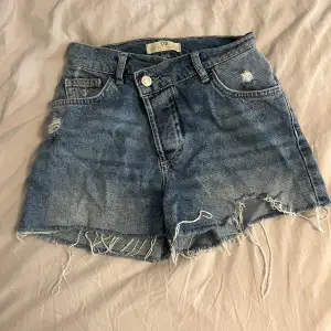 Jättefina blå jeansshorts, modellen har en sne gylf, midwaist. Använda max 3 gånger!💗