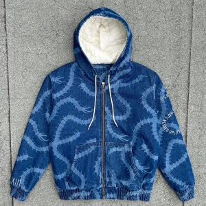 Blå jeansjacka med mönster - Säljer en blå jeansjacka med ett unikt mönster som ser ut som slingrande ormar inspired av Tokyo ghoul. Den har Jackan har en dragkedja framtill och en mysig huva med vit vaddering på insidan.