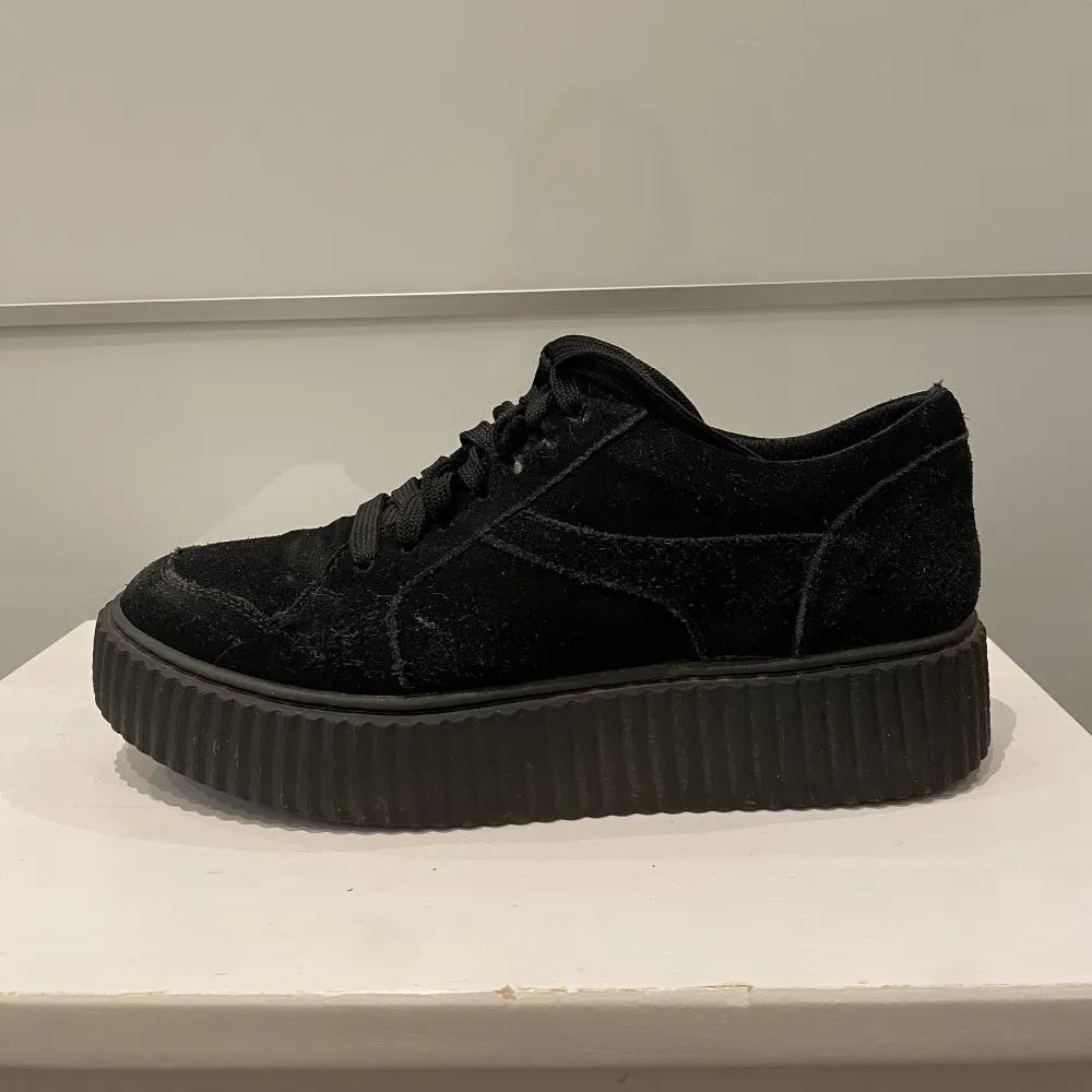 Svart sneakers i mocka imitation.  Är i gott skick förutom en liten defekt vid skosnörningen (se bild). Skor.