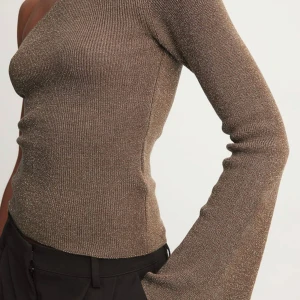 One shoulder topp - Supersnygg one shoulder topp med vid ärm och glitter textur i tyget. Aldrig använd, lappen sitter kvar! Köpt för 500 kr🎀